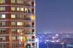 Apartment windows in the night time.  Big city living in highrise urban environment.  Real estate concept.