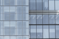 Building facade with modern window design for steel glass office tower.  Copy space and fade.