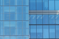 Building facade with modern window design for steel glass office tower.  Copy space and fade.