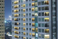 Residential apartment windows at night for electrical and power energy concept.  Individual living spaces and urban sprawl to highrise buildings.