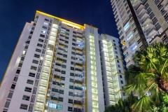 Tropical palm trees and apartment windows at night.  Highrise housing in large urban cities for rental and buyers housing mortgage concept.