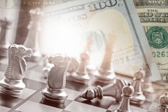 Business competition in chess battle with american dollars and money gain for capital gain.  Financial planning and investing.