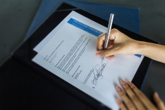 Financial business contract.  Reading paperwork details and signing business contract.