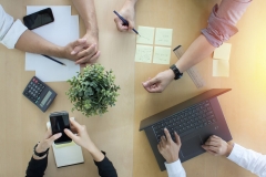 Teamwork collaboration with top-down desk view at office.  Brainstorming and setting goals working together.