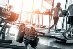 Healthy lifestyle fitness concept with rows of dumbbells and in the gym and a personal trainer for lifestyle concept for muscle building, strength, and weight loss.