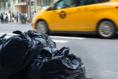 Trash bags with blurry traffic in background in urban environment with recycle concept.