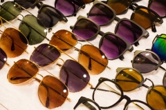Assorted sunglasses for sale at a local market with nice discounted lenses and apparel for all kinds of people to wear.  Improves vision and reduces UV glare.