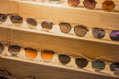 Sunglasses shop with huge sale on eye vision this weekend.  Glasses discounts and promotions with guarantee on wooden shelves.  Road side shop.